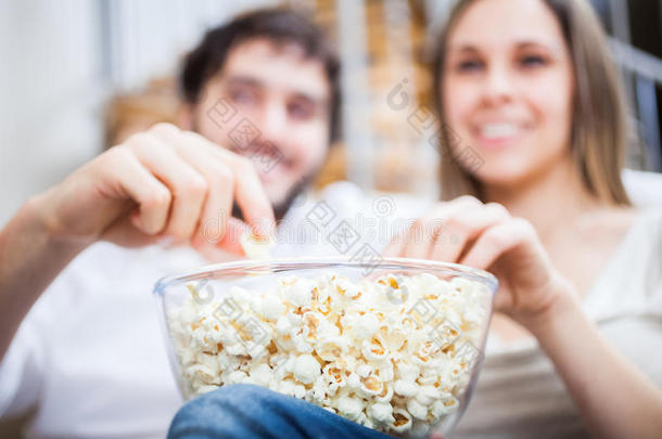 一对夫妇一边看电影一边吃爆米花