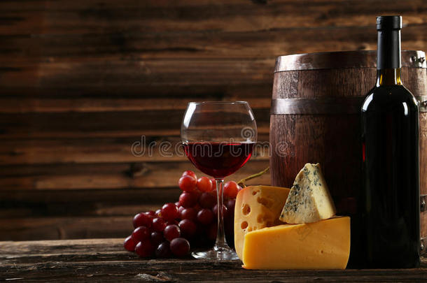 棕色木制<strong>背景</strong>上的一杯<strong>红酒</strong>、奶酪和<strong>葡萄</strong>