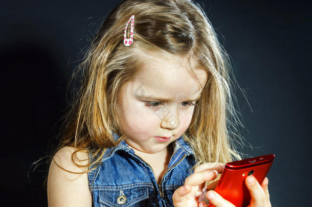 可爱的小女孩用<strong>新手机</strong>说话。