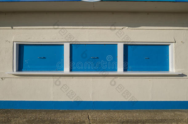 奶油大厦亭子上封闭的蓝色百叶窗
