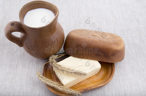 新<strong>鲜牛奶</strong>，黄油在亚麻桌布上的天然陶器中