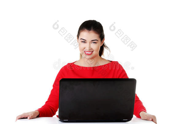 前台女士坐在办公桌前拿着笔记本电脑