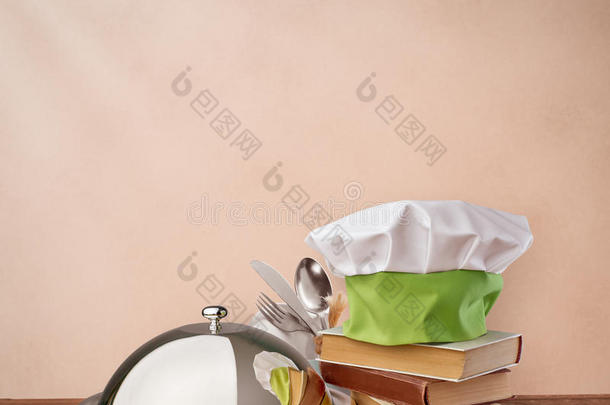食物托盘，帽子厨师和烹饪书在米色复古背景