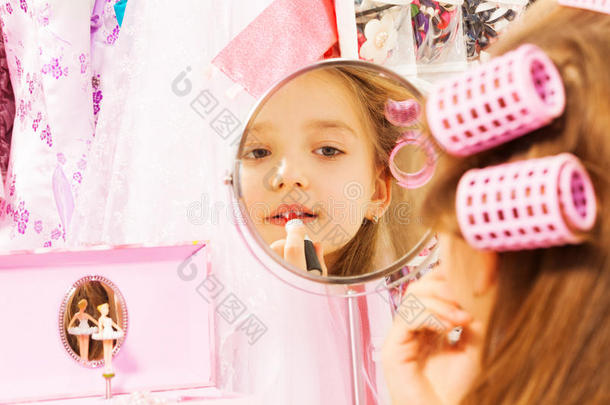 可爱的女孩在镜子里化妆