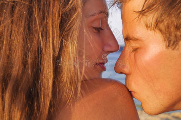 日落时分在海滩上亲吻的情侣