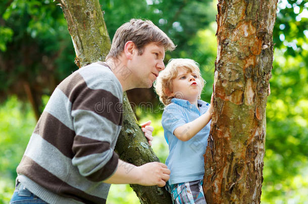 可爱的小男孩喜欢和父亲一起爬树，胜过