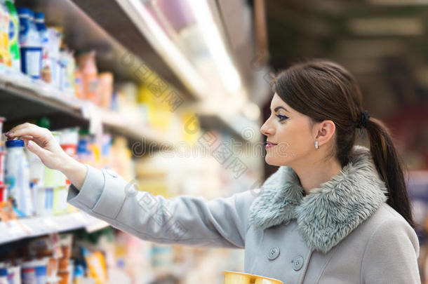 美丽的年轻女人在杂货店超市购物