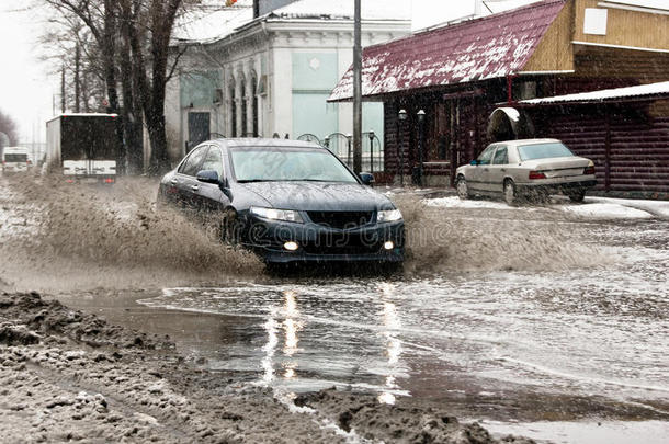 春天的雪街上，脏水从汽车车轮上溅出来