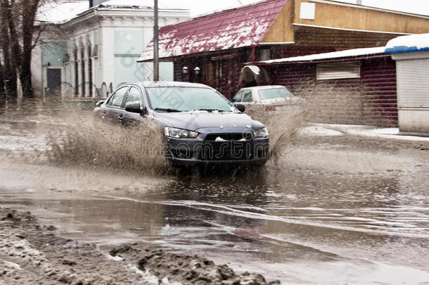春天的雪街上，脏水从汽车车轮上溅出来