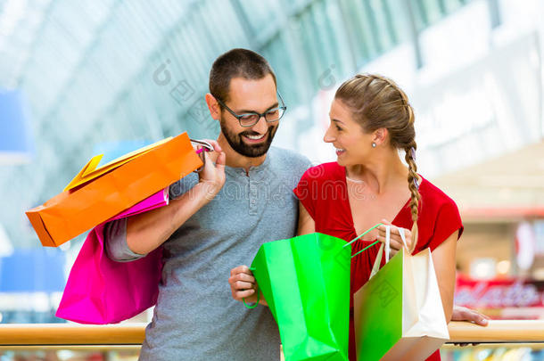 一对夫妇带着袋子在<strong>商场</strong>购物
