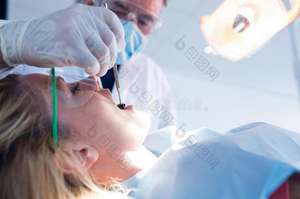 牙医在明亮的光<strong>线下</strong>检查病人的牙齿