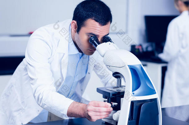 理科学生透过显微镜看