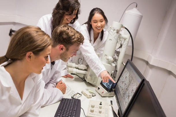 生物化学学生使用大型显微镜和计算机