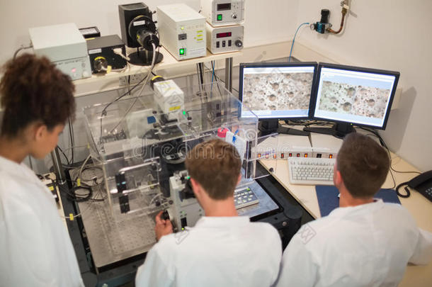 生物化学学生使用大型显微镜和计算机