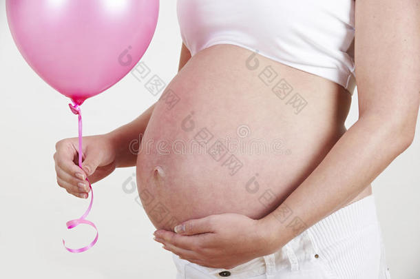 孕妇抱着粉红色气球的特写镜头