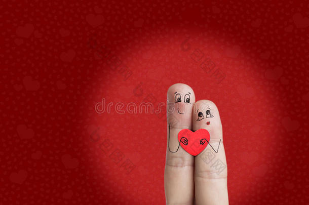 一对幸福夫妇的手指艺术。 恋人们拥抱着红色的心。 股票形象