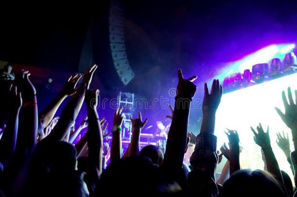 一群人在摇滚音乐会上举手