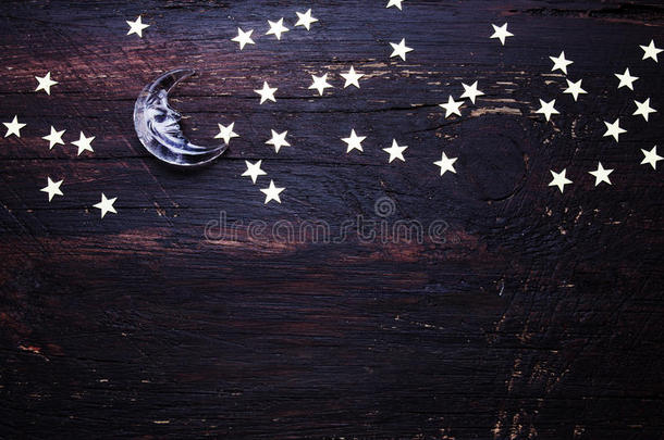 闪闪发光的金色星星和玻璃月亮在粗糙的木头上