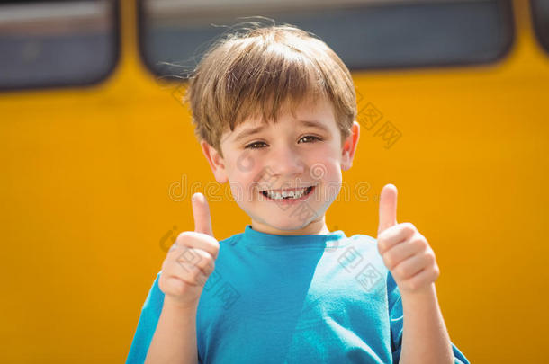 可爱的小学生在校车旁对着镜头微笑
