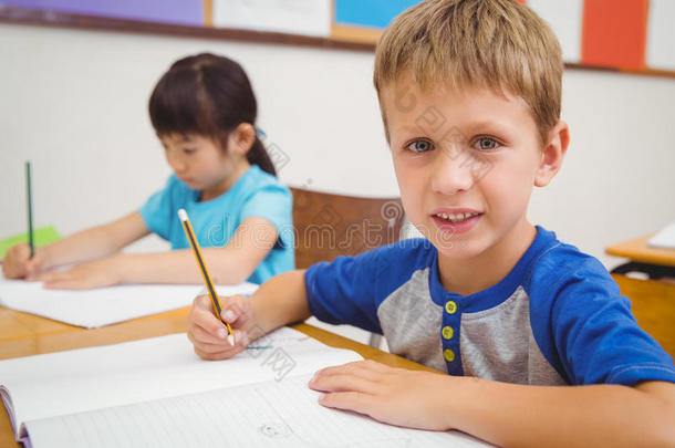 可爱的小学生在课桌前画画