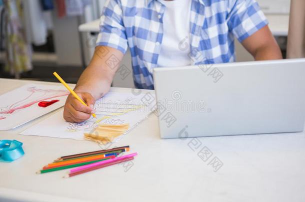 大学生在画画时使用笔记本电脑
