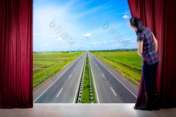 女孩打开窗帘，看着公路