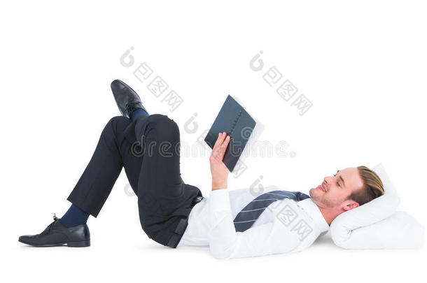 轻松的商人躺着看书