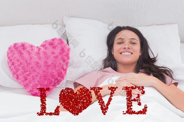 女人躺在<strong>床</strong>上的复合图像，旁边是一个粉红色的心枕