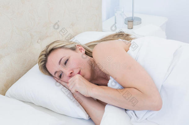 精疲力竭的金发女人在床上哭