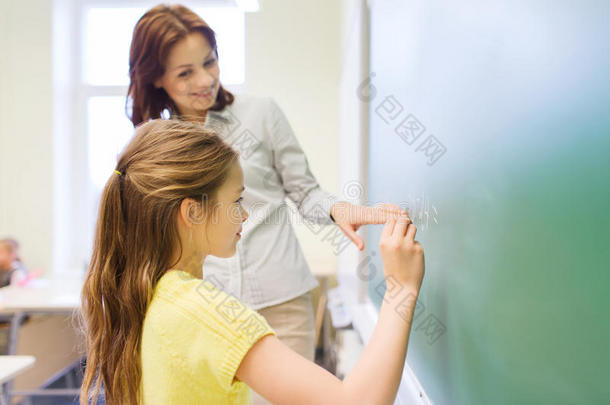 微笑的小女生在黑板上写字