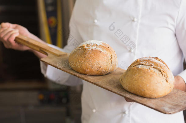 面包师展示了<strong>一盘新鲜</strong>面包