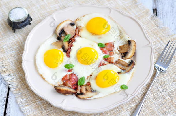 早餐煎鸡蛋，在木桌上放培根和蘑菇