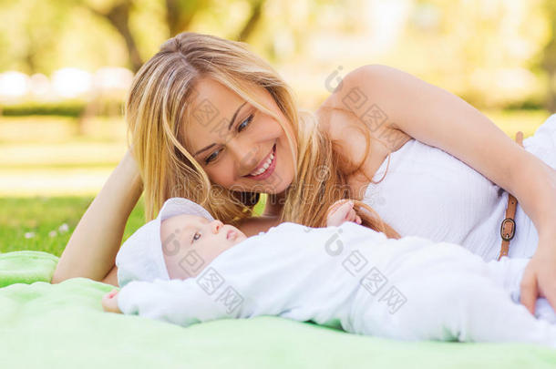 快乐的妈妈躺在毯子上，小宝宝躺在床上