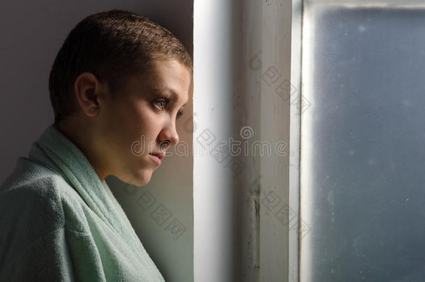 站在医院橱窗前的年轻癌症病人