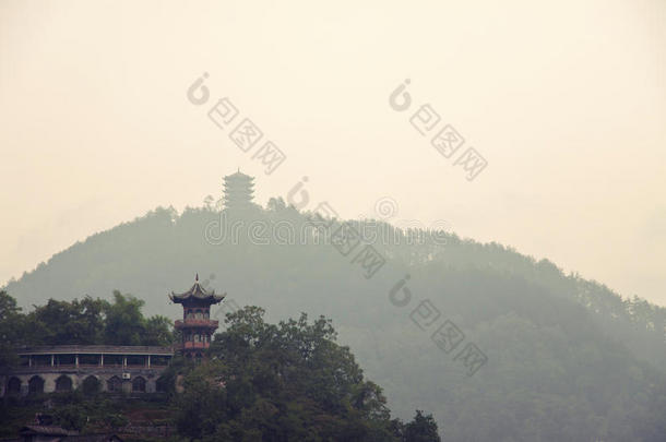 中国宝塔在一座青山上，另一座宝塔的轮廓