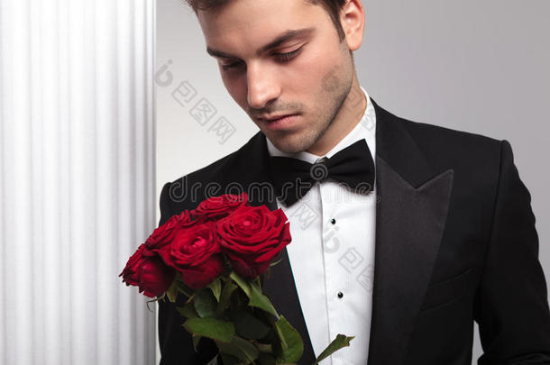 优雅的商人看着<strong>红玫瑰</strong>花束