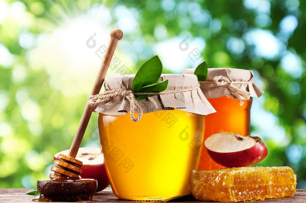 装满<strong>蜂蜜</strong>、<strong>苹果</strong>和梳子的玻璃罐。