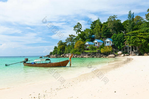 泰国海滩上的船和平房。