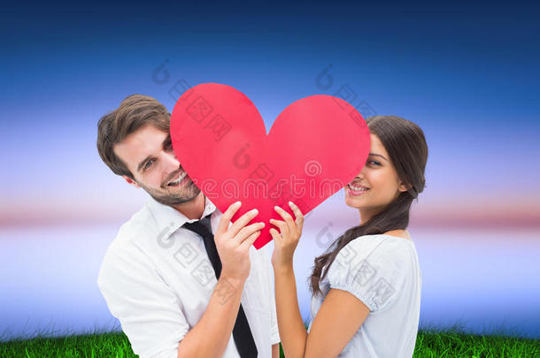一对夫妇抱着一颗心对着相机微笑的复合图像