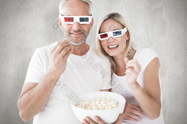 幸<strong>福</strong>夫妇戴着3D眼镜吃爆米花的复合图像
