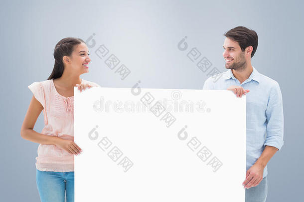 有吸引力的年轻夫妇微笑和持有海报的复合图像