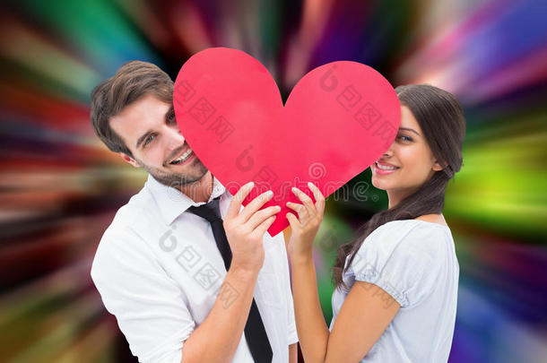 一对夫妇抱着一颗心对着相机微笑的复合图像