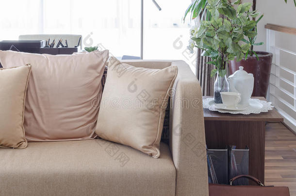 棕色沙发，带枕头，木制桌子上有茶杯，在客厅里