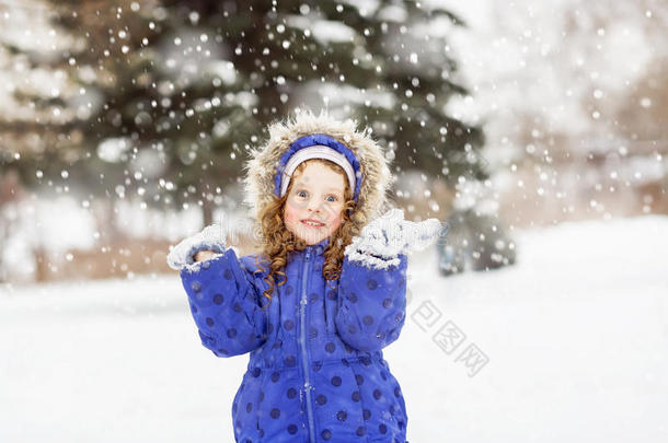 有趣的女孩举起双手在空中，捕捉雪
