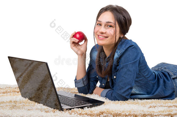 女孩在地毯上拿着笔记本电脑和苹果