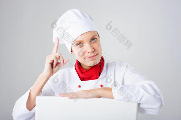厨师标志。 女厨师在看纸标志广告牌。 惊讶和有趣的表情女人孤立在白色背景上