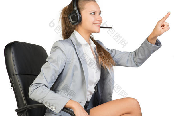 戴耳机的女商人坐在办公椅上