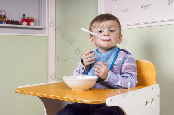 可爱的蹒跚学步的孩子吃酸奶