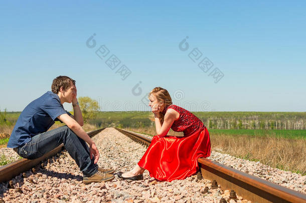 一对夫妇坐在铁路上