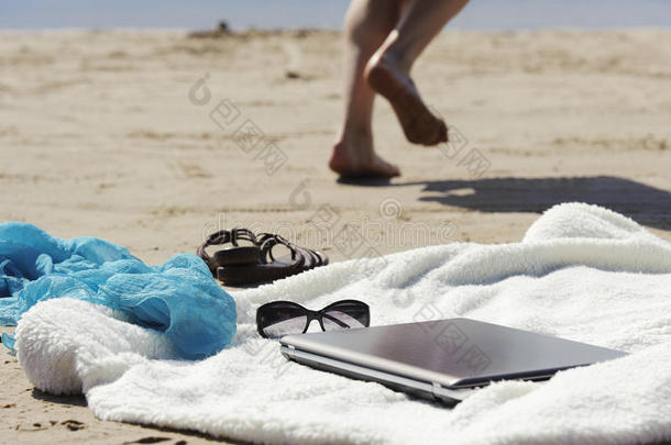 沙滩上的包裹、笔记本电脑、围巾和骡子